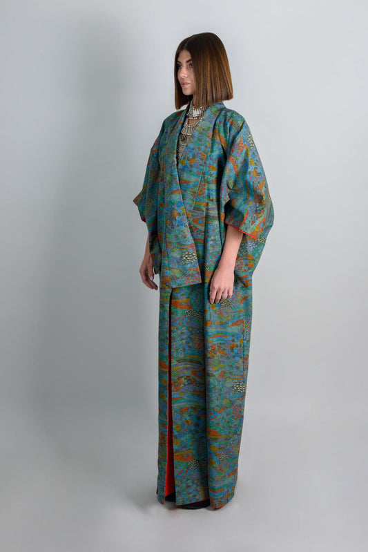 May include: A long, blue and green patterned robe with a red lining. The robe has a wide collar and long sleeves. The robe is made of a soft, flowing fabric.