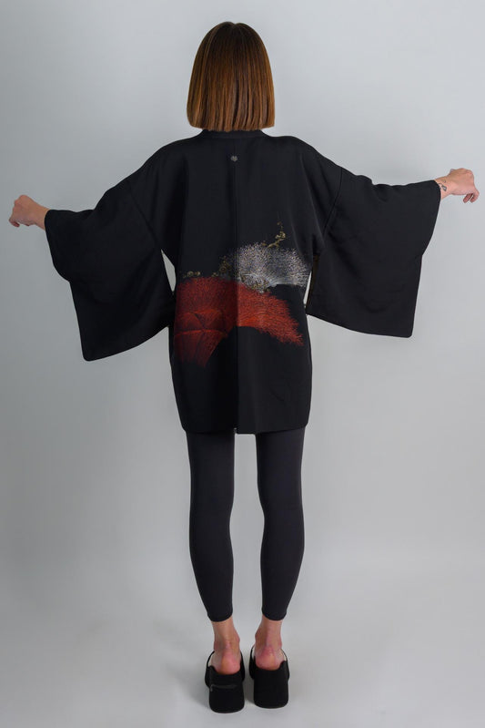 May include: A black kimono with red and silver embroidery. The kimono is worn over black leggings.
